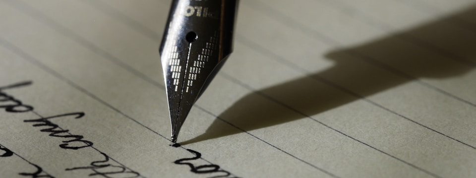 A pen and handwritten words on a page